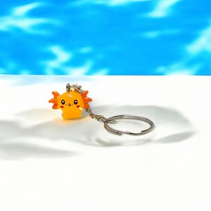 Our Mini Axolotl Keychain is the perfect balance of cute and collectible. Designed to bring joy, it’s great for attaching to keys, lanyards, or backpacks. This tiny creature’s adorable face makes it irresistible—perfect as a small gift for birthdays, holidays, or just to brighten someone’s day!