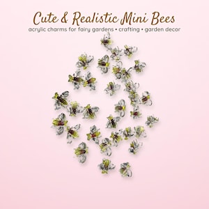 May include: A collection of small bee-shaped acrylic charms featuring yellow and black striped bodies with clear wings. The text Cute & Realistic Mini Bees acrylic charms for fairy gardens • crafting • garden decor is printed above the charms.