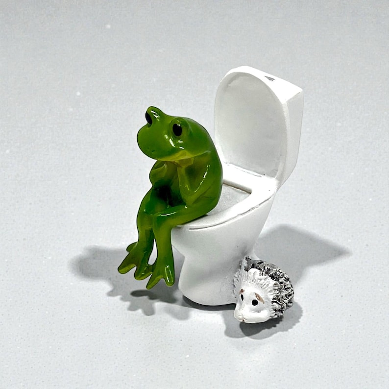 This funny frog on toilet figurine is the perfect blend of cute and silly bathroom decor. Designed to spark laughs instantly, this whimsical frog statue makes a great gag gift, stocking stuffer, or novelty home accent. Ideal for frog lovers, funny gift collectors, and anyone who enjoys playful bathroom humor. A small but unforgettable conversation-starting frog figurine.