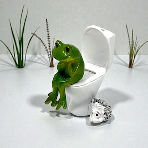 Bring humor to your home with this funny frog toilet figurine. Designed for laughs, this silly frog decor is perfect for bathrooms, guest spaces, offices, and dorm rooms. A popular novelty gift and stocking stuffer, it’s a unique frog statue that frog lovers and humor fans can’t resist.