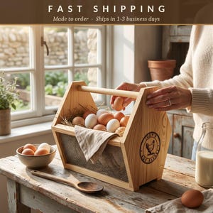 A fast shipping banner notes each basket is made to order and ships in 1 to 3 business days, above a lifestyle photo of the engraved basket brimming with eggs. This personalized egg collection basket is a handmade farmhouse egg gathering basket, a solid pine wood egg and produce basket with breathable metal mesh sides, a smooth sanded dowel carry handle, and a laser engraved front panel, about 12 inches long, 7.5 inches wide and 10 inches tall. A custom chicken egg basket, engraved egg...