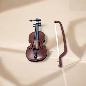 May include: A miniature brown violin with black strings and a matching bow. The violin has a classic shape with f-holes and a chin rest. The bow is curved with a white string. The violin and bow are likely decorative items.