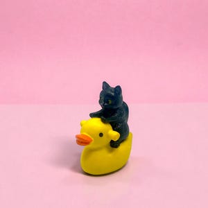Give a gift that guarantees laughs with this mini cat riding duck figurine. Its charming, handcrafted details make it a standout stocking stuffer, white elephant gift, or funny desk accessory. Perfect for quirky décor lovers, cat parents, and miniature collectors, it adds personality and humor to any space while showing off your unique gift-giving style.