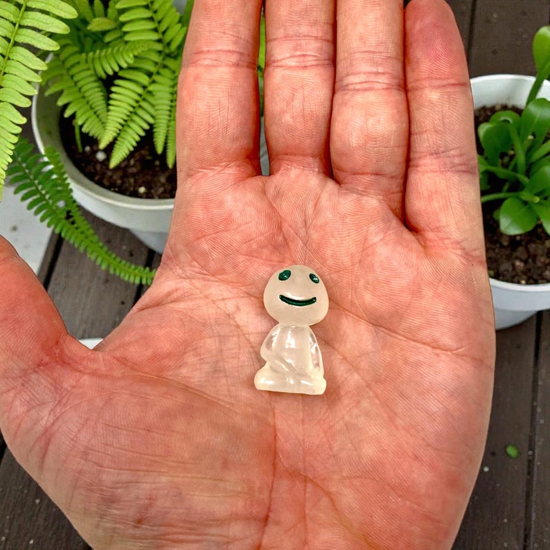 Create a cozy woodland atmosphere with this Kodama Tree Spirit figurine for plants and home decor. These tiny guardians of the forest bring calm, charm, and whimsy to terrariums, planters, and shelves. Ideal for plant lovers who enjoy unique accessories, this miniature nature spirit also makes a delightful gift for birthdays, housewarmings, or anyone who appreciates magical decor.
