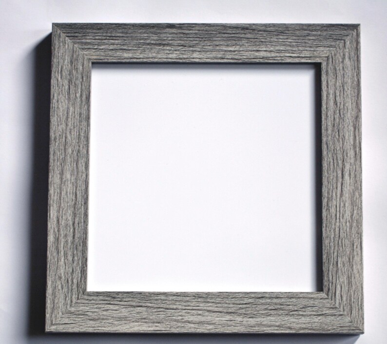 May include: A gray wood picture frame with a white mat.