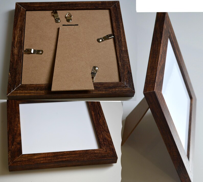May include: A dark brown wooden picture frame with a white mat and a clear glass front. The frame has a easel back for tabletop display and hanging hardware on the back.