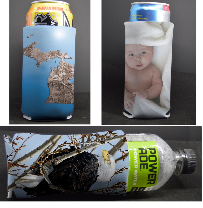 May include: Three different can coolers with various designs. The first cooler is blue with a brown outline of the state of Michigan. The second cooler is white with a baby wrapped in a white towel. The third cooler is a close-up of a bald eagle perched on a branch with a blue sky in the background. The cooler is wrapped around a clear plastic bottle with a green label that says "POWERADE POWER WATER".