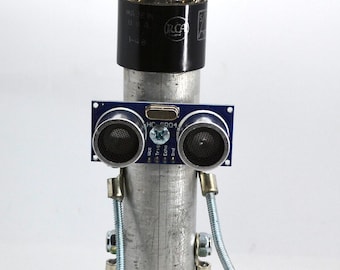 robot, bot, sculpture art assemblage figure created with found recycled materials old tube head  pipe and laser eyes