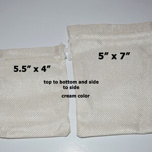May include: Two cream-colored drawstring bags made of a woven fabric. The smaller bag measures 5.5 inches by 4 inches and the larger bag measures 5 inches by 7 inches.