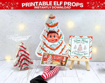 Könnte beinhalten: Druckbare Elf-Requisiten mit Weihnachtsmotto. Das Bild zeigt eine weihnachtsbaumförmige Requisite, ein Schild mit der Aufschrift "Farm Fresh" und eine Schachtel mit Weihnachtsleckereien. Die Requisiten befinden sich auf einer weißen Oberfläche.