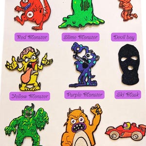 May include: Nine embroidered iron-on patches featuring various cartoon monsters, a ski mask, and a race car. The patches are colorful and feature different designs, including a green slime monster, a yellow monster with a brain, a purple monster with spots, and a red monster with two eyes.