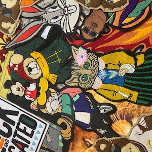 May include: A collection of colorful embroidered patches featuring various cartoon characters, animals, and designs. The patches include a crown, a cat, a bear, a Mickey Mouse character, a Bugs Bunny character, and a black and white patch with the text "Black and Educated".