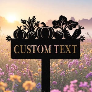 Puede incluir: Señal de jardín de metal negro con una parte superior decorativa con siluetas de verduras. El letrero dice "CUSTOM TEXT" en letras doradas. Ideal para un marcador de jardín personalizado.