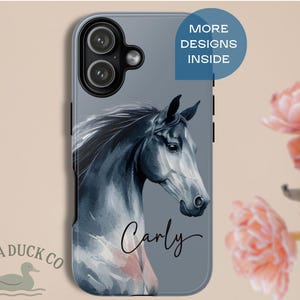 May include: A phone case featuring a watercolor illustration of a horse's head in shades of gray and black. The name "Carly" is written in cursive. The case has a gray background with the text "MORE DESIGNS INSIDE" in a blue circle. The Mama Duck Co. logo is in the bottom left.