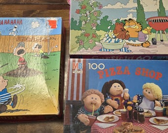 3 Vintage Picture Jigsaw Puzzles; Peanuts 1965, Garfield 1978, and Cabbage Patch Pizza Shop 1990.