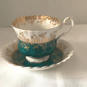 Xícara e pires Royal Albert da série Regal, em verde-azulado e branco.