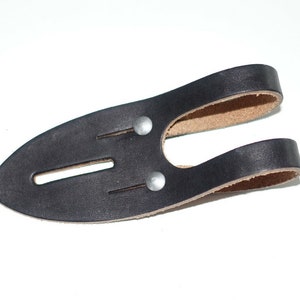 May include: Black leather knife sheath with two metal rivets and a loop for attaching to a belt.