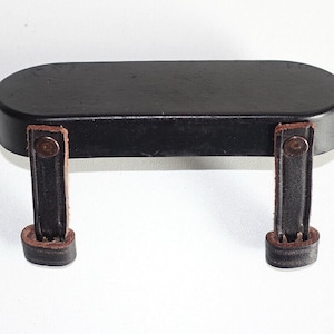 May include: Black leather camera strap with two brown leather straps and metal buckles.