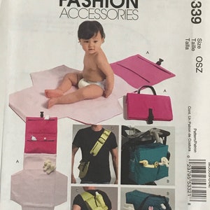 May include: McCall's Fashion Accessories pattern M5339. The image shows a baby and several examples of baby accessories, including a changing pad, a diaper bag, and a stroller organizer. The pattern includes instructions for making these items.
