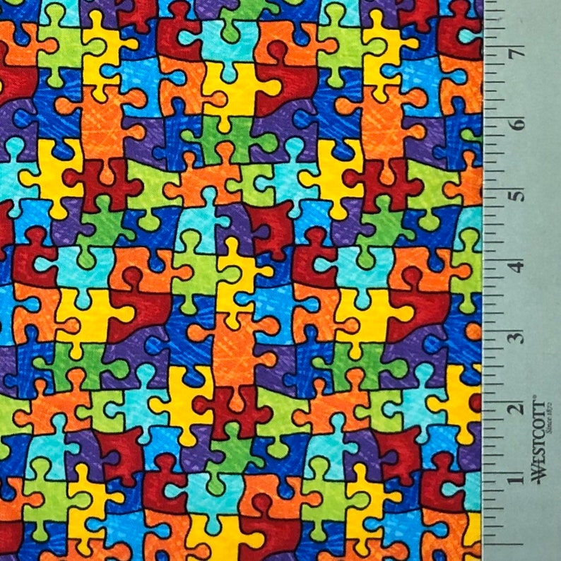 May include: A colorful fabric with a repeating pattern of puzzle pieces in shades of blue, green, red, yellow, and orange.