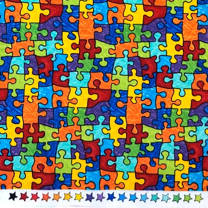 May include: A colorful fabric with a repeating pattern of puzzle pieces in shades of red, orange, yellow, green, blue, and purple. The puzzle pieces are outlined in black.