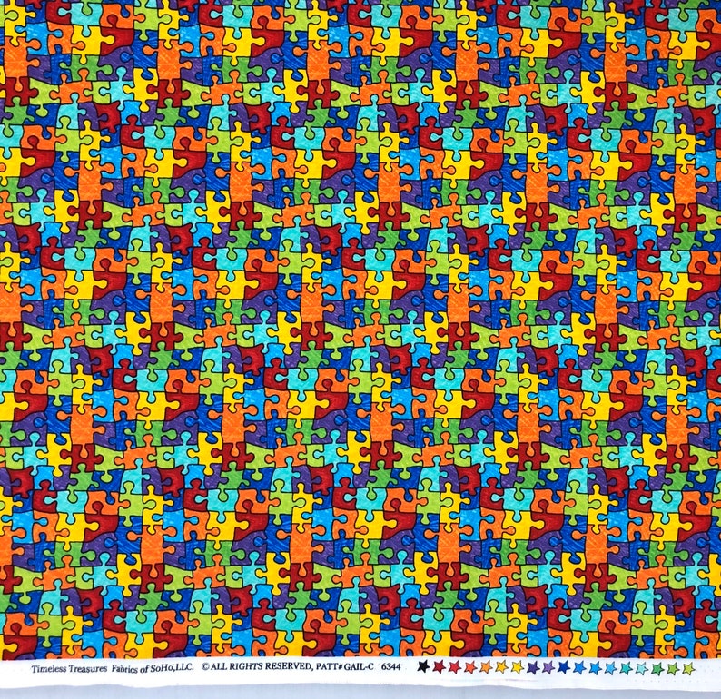 May include: A colorful fabric with a repeating pattern of puzzle pieces in shades of red, orange, yellow, green, blue, and purple. The puzzle pieces are outlined in black and have a textured appearance.