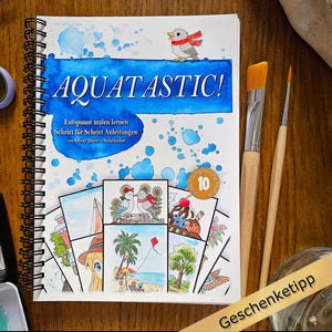 Könnte beinhalten: Ein Spiralbuch mit dem Titel "AQUATASTIC!" mit blau-weißem Cover, das einen Cartoon-Vogel und Aquarellillustrationen zeigt. Pinsel, eine Aquarellpalette und eine Schere sind ebenfalls zu sehen, was auf ein Malthema hindeutet.