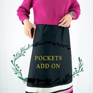 Könnte beinhalten: Ein schwarzer Rock mit einem rosa-weißen Streifen am Saum. Der Rock hat einen Textüberlagerung, der "POCKETS ADD ON" lautet.