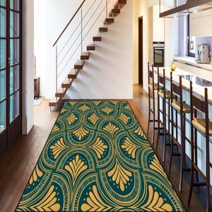May include: A rectangular rug with a teal and gold art deco design. The rug is in a hallway with wooden flooring, a staircase, and a kitchen in the background. The pattern features stylized floral and geometric shapes.