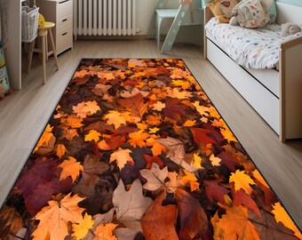 Puede incluir: Alfombra rectangular con un diseño de hojas de otoño. La alfombra muestra un patrón denso de hojas caídas en tonos naranja, amarillo, marrón y rojo, creando una estética cálida. La alfombra tiene un borde negro.