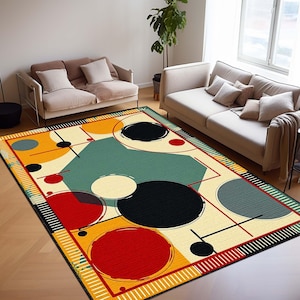 May include: A rectangular rug with a bold geometric pattern. The rug's design incorporates large circles and shapes in black, red, yellow, and teal on a cream background. Black lines and a striped border complete the design.