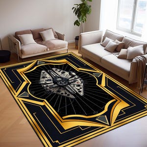 Puede incluir: Alfombra rectangular negra con un borde geométrico dorado y negro. La alfombra presenta una ilustración detallada de la nave espacial Millennium Falcon en el centro, sobre un fondo negro con líneas radiales. La alfombra está colocada en un salón.
