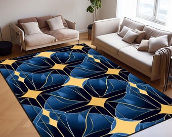May include: A large area rug with a repeating pattern of blue, gold, and navy shapes. The rug is placed in a living room setting, with two sofas and a window visible in the background. The design features abstract, geometric forms.
