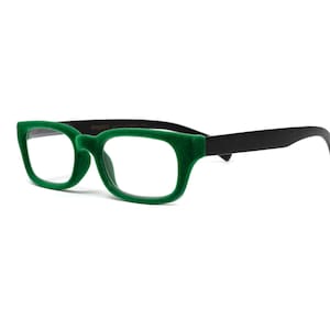 May include: Eyeglasses with a bold, rectangular frame. The front of the glasses is a vibrant green, while the arms are black. The lenses are clear. The glasses are set against a white background.