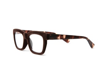 May include: Brown velvet framed eyeglasses with tortoise shell arms.