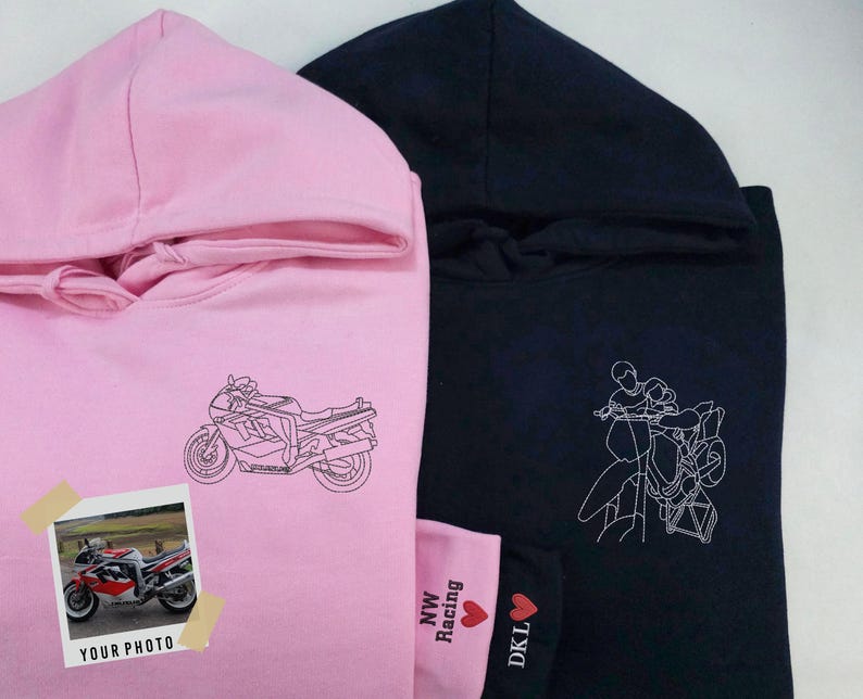 Puede incluir: Dos sudaderas con capucha, una rosa y otra negra, con diferentes dise&ntilde;os gr&aacute;ficos. La sudadera rosa presenta un dibujo lineal de una motocicleta, mientras que la sudadera negra presenta un dibujo lineal de dos personas conduciendo una motocicleta. La sudadera rosa tiene el texto "NW Racing" y "DKL" en la esquina inferior derecha.