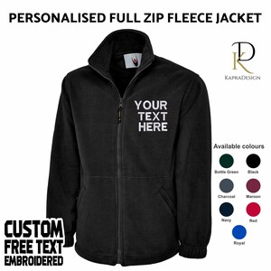 May include: Black full zip fleece jacket with a white embroidered text that says "YOUR TEXT HERE". The jacket is available in a variety of colors, including bottle green, black, charcoal, maroon, navy, red, and royal.