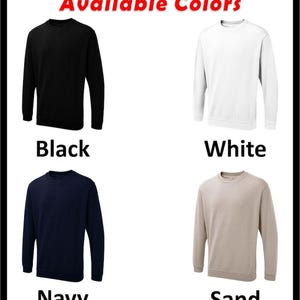 May include: Four crewneck sweatshirts in different colors: black, white, navy blue, and sand. The text "Available Colors" is at the top of the image.