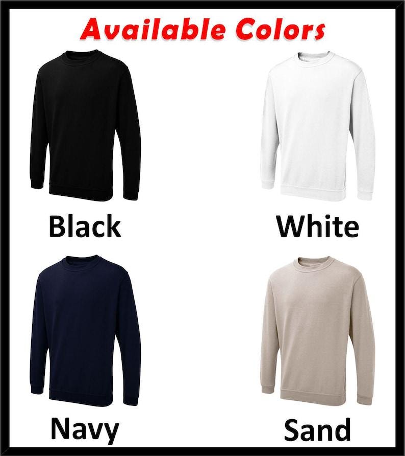 May include: Four crewneck sweatshirts in different colors: black, white, navy blue, and sand. The text "Available Colors" is at the top of the image.