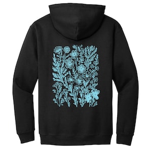 May include: Black hooded sweatshirt with a light blue floral design on the back.
