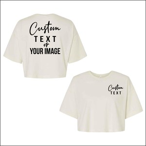 May include: Two cream-colored crop tops. One displays "Custom TEXT or YOUR IMAGE" in black script on the back. The other has "Custom TEXT" in black script on the front. Both have short sleeves and a relaxed fit.
