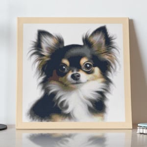 May include: A framed print of a black and white chihuahua dog with brown markings. The print is hanging on a white wall above a wooden dresser with a black lamp and a cup of coffee.