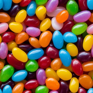 Könnte beinhalten: Nahaufnahme eines Haufens bunter Geleebohnen. Die Geleebohnen sind in verschiedenen Farben, darunter Gelb, Orange, Rot, Blau, Grün und Lila. Die Süßigkeiten sind oval und glänzend.