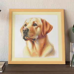 May include: A framed cross-stitch portrait of a golden Labrador Retriever. The dog is depicted in shades of yellow, tan, and brown, with a detailed rendering of its fur and facial features. The artwork is set within a light wooden frame.