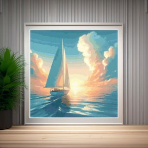 Op de afbeelding: Een ingelijst kunstwerk toont een zeilboot op het water bij zonsondergang. De lucht gaat over van blauw naar oranje en geel, met pluizige wolken. De zeilboot heeft een wit zeil en wordt weerspiegeld in het water. Het kunstwerk wordt tentoongesteld op een houten oppervlak.