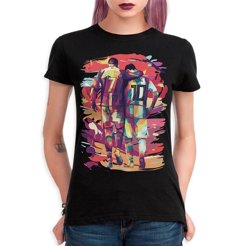 May include: Black t-shirt with a colorful graphic of two soccer players, one with the name "Ronaldo" and the number "7" on their jersey, and the other with the name "Messi" and the number "10" on their jersey.