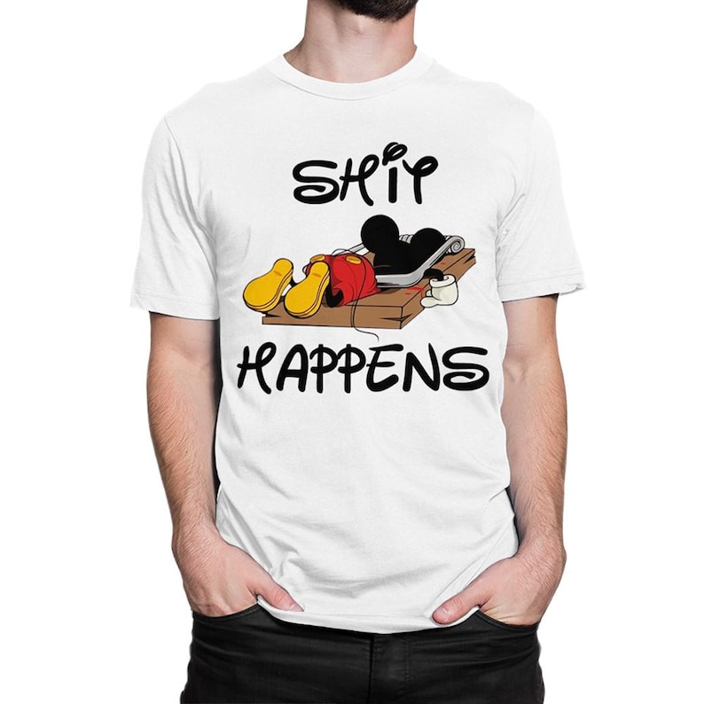 Puede incluir: Camiseta blanca con una imagen de dibujos animados de Mickey Mouse atrapado en una trampa para ratones. El texto "SHIT HAPPENS" est&aacute; impreso debajo de la imagen.