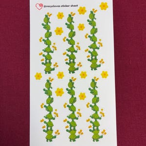 May include: A sticker sheet featuring rows of green turtle illustrations stacked on top of each other, holding yellow flowers. Yellow flower stickers are scattered around the turtles. The text "@recyccloves sticker sheet" is at the top.