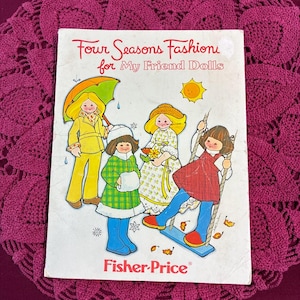 May include: A vintage Fisher-Price booklet titled Four Seasons Fashions for My Friend Dolls. The cover features a colorful illustration of four dolls dressed in seasonal clothing, including a yellow raincoat, a green winter coat, a floral dress, and a red dress.
