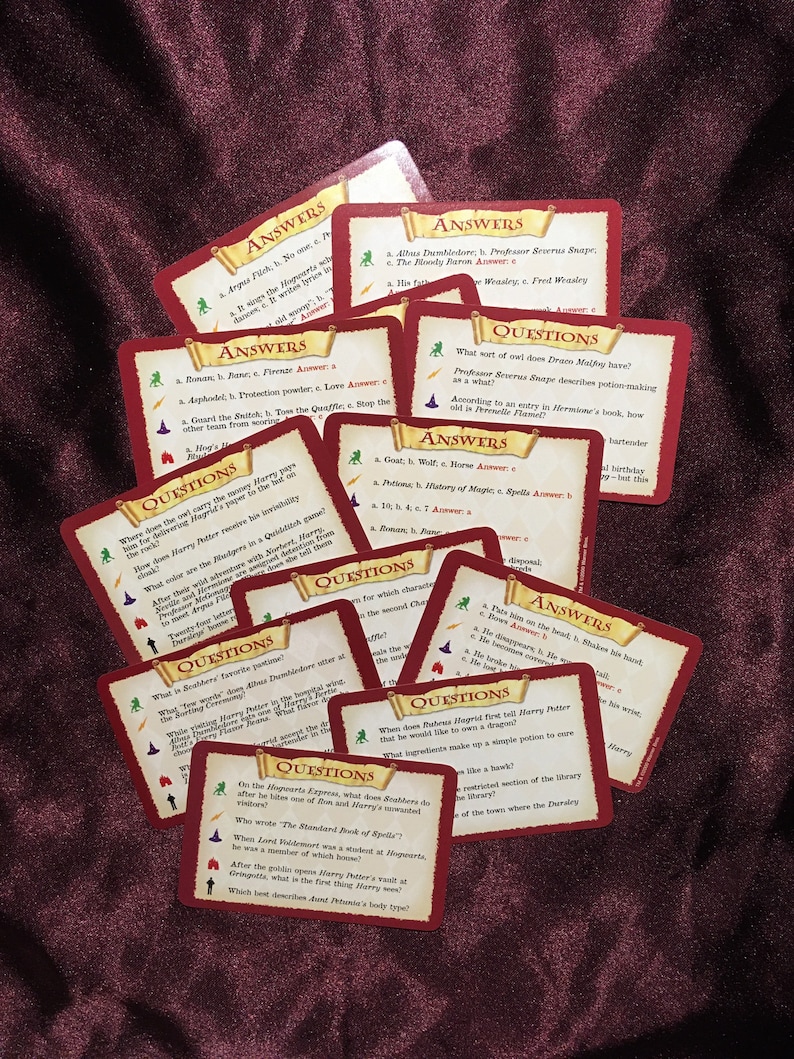 May include: A set of colorful cards with questions and answers about the Harry Potter universe. The cards are red with gold accents and feature illustrations of various characters and objects from the books.